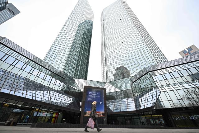 (FILES) A woman walks past Deutsche Bank headquarters in Frankfurt am Main, on January 28, 2026, as German prosecutors and police on searched the bank's headquarters in an investigation over suspected money laundering offences, officials said. Germany's Deutsche Bank said on July 22, 2026 that prosecutors had searched its headquarters in Frankfurt, with media reports saying the probe is linked to alleged "cum-ex" fraud. Cum-ex cases involve investors rapidly trading shares and creating confusion about who owns them when, to allow multiple people to claim rebates on taxes that were paid only once. (Photo by Kirill KUDRYAVTSEV / AFP)