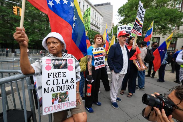 Demonstrators hold signs in support of ousted Venezuelan president Nicholas Maduro and his wife Cilia Flores, outside the Daniel Patrick Moynihan Federal Courthouse in New York City on July 22, 2026. Venezuela's ousted president Nicolas Maduro is set to appear in federal court Wednesday, his third public hearing since the US military captured him in a stunning nighttime raid in January. The former leader, 63, and wife Cilia Flores have been held in a Brooklyn jail since the US military operation, awaiting trial on drug trafficking, firearms and other charges. (Photo by TIMOTHY A. CLARY / AFP)