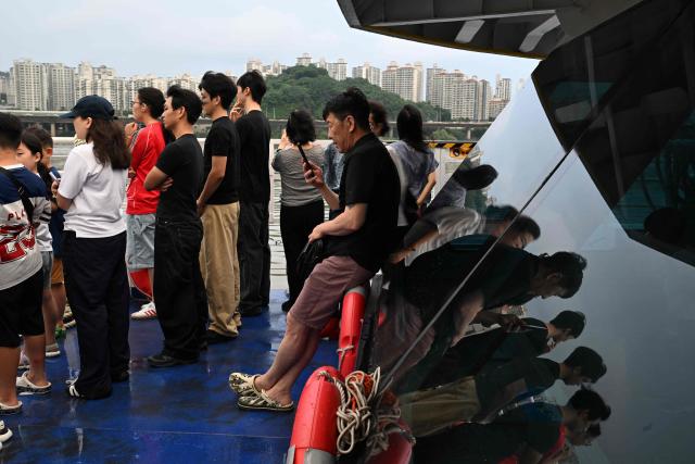A man makes a phone call while riding on a ferry on the Han River in Seoul on July 22, 2026. (Photo by GREG BAKER / AFP)