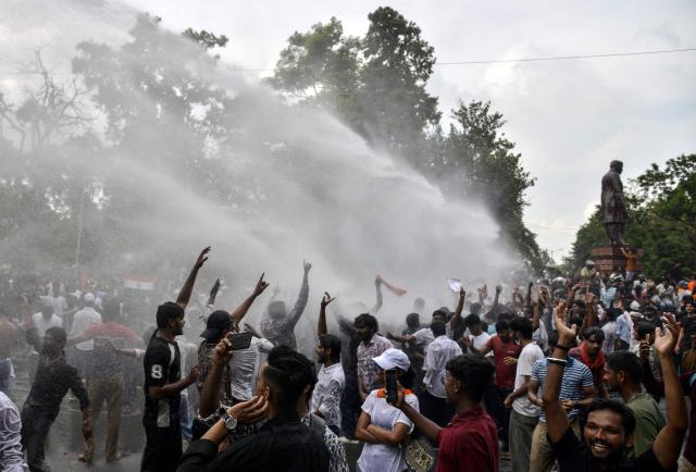 Police personnel use water cannons to disperse demonstrators during a protest march in Patna on July 22, 2026 demanding the resignation of India’s Education Minister Dharmendra Pradhan over alleged NEET exam irregularities. The protests, led by the social media-driven Cockroach Janta Party (CJP) movement, have emerged as one of the biggest challenges to Prime Minister Narendra Modi's government since his re-election in 2024. (Photo by Sachin KUMAR / AFP)