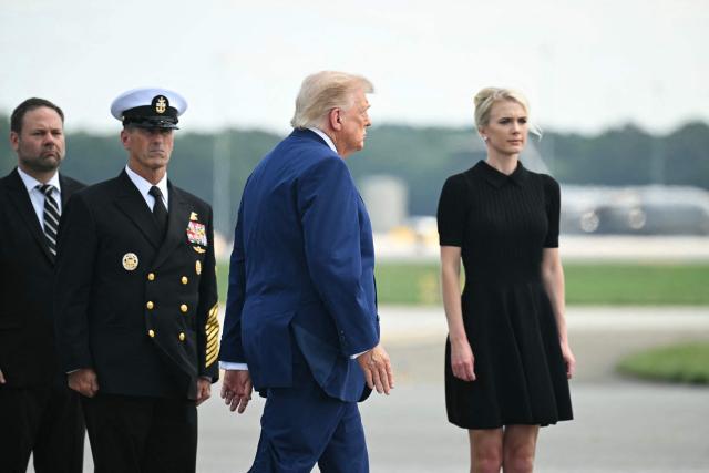 US President Donald Trump and Natalie Harp (R), aide to President Trump, attend a dignified transfer solemn event for US service members killed during operations in the Middle East, at Dover Air Force Base in Dover, Delaware, on July 22, 2026.  (Photo by SAUL LOEB / AFP)