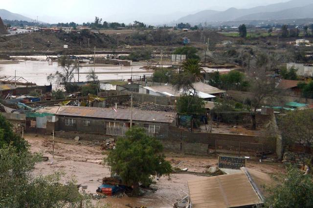 View of a flooded rural area near the outlet of a river in Coquimbo region, Chile, on July 21, 2026, following severe weather conditions. Heavy rains in Chile have killed at least 13 people and left more than 60,000 others cut off due to washed out roads, government officials said in a report on July 21, 2026, as the recovery effort focused on restoring basic services. (Photo by Armando Gonzalez / AFP)