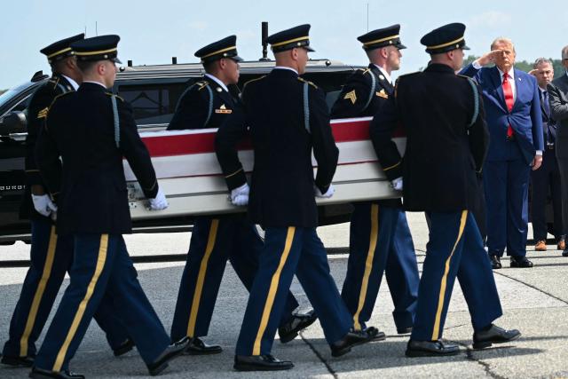 US President Donald Trump salutes as a US Army carry team carries the flag-draped transfer case containing the remains of Sgt. Angel S. Rampersad, 28, of Ozone Park, New York, during a dignified transfer solemn event for US service members killed during operations in the Middle East, at Dover Air Force Base in Dover, Delaware, on July 22, 2026. According to the US Department of Defense, Rampersad is believed to have been killed in action on July 17 during an enemy attack at Muwaffaq Salti Air Base in Jordan. (Photo by SAUL LOEB / AFP)