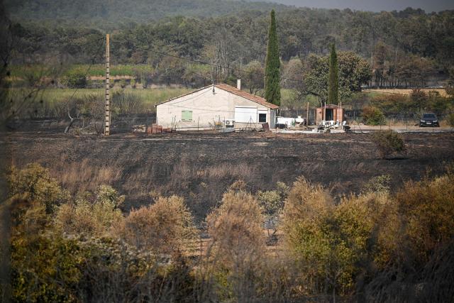 This photograph shows a house in a burnt area as a wildfire flares up again in Ponteves, southeastern France on July 22, 2026. Firefighters have managed to contain the fierce blaze that swept through 2,550 hectares in the Var in less than a day, forcing the evacuation of around 500 people, and which on July 22, 2026 is still burning across a vast mountainside. (Photo by Frederic Dides / AFP)