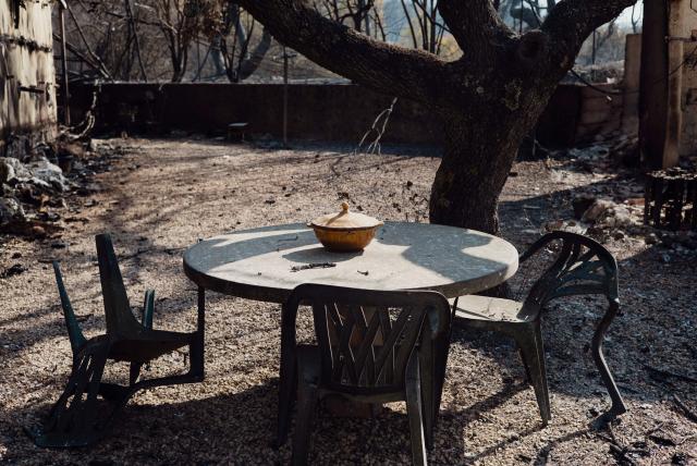 This photograph shows the garden table at a house in a burnt area as a wildfire flares up again in Ponteves, southeastern France on July 22, 2026. Firefighters have managed to contain the fierce blaze that swept through 2,550 hectares in the Var in less than a day, forcing the evacuation of around 500 people, and which on July 22, 2026 is still burning across a vast mountainside. (Photo by Frederic DIDES / AFP)