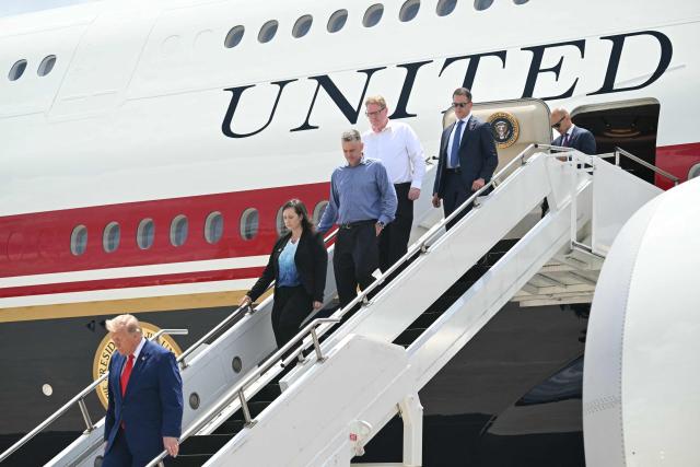 US President Donald Trump disembarks from Air Force One with family members of Tyler Feehan, one of the servicemen repatriated to Dover, Delaware, earlier in the day upon arrival at Dobbins Air Reserve Base in Marietta, Georgia, July 22, 2026. Trump is travelling to Wheeler High School in Marietta, Georgia, to deliver remarks. (Photo by SAUL LOEB / AFP)