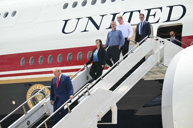 US President Donald Trump disembarks from Air Force One with family members of Tyler Feehan, one of the servicemen repatriated to Dover, Delaware, earlier in the day upon arrival at Dobbins Air Reserve Base in Marietta, Georgia, July 22, 2026. Trump is travelling to Wheeler High School in Marietta, Georgia, to deliver remarks. (Photo by SAUL LOEB / AFP)