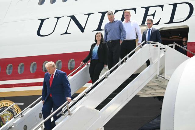 US President Donald Trump disembarks from Air Force One with family members of Tyler Feehan, one of the servicemen repatriated to Dover, Delaware, earlier in the day upon arrival at Dobbins Air Reserve Base in Marietta, Georgia, July 22, 2026. Trump is travelling to Wheeler High School in Marietta, Georgia, to deliver remarks. (Photo by SAUL LOEB / AFP)