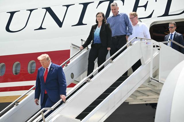 US President Donald Trump disembarks from Air Force One with family members of Tyler Feehan, one of the servicemen repatriated to Dover, Delaware, earlier in the day upon arrival at Dobbins Air Reserve Base in Marietta, Georgia, July 22, 2026. Trump is travelling to Wheeler High School in Marietta, Georgia, to deliver remarks. (Photo by SAUL LOEB / AFP)