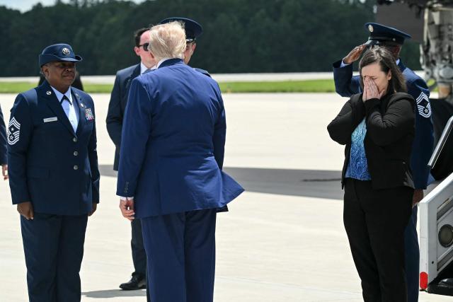 US President Donald Trump disembarks from Air Force One with family members of Tyler Feehan, one of the servicemen repatriated to Dover, Delaware, earlier in the day upon arrival at Dobbins Air Reserve Base in Marietta, Georgia, July 22, 2026. Trump is travelling to Wheeler High School in Marietta, Georgia, to deliver remarks. (Photo by SAUL LOEB / AFP)
