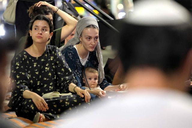 Religious and secular Israelis gather to read excerpts from the biblical Book of Lamentations in the Israeli coastal city of Tel Aviv on July 22, 2026, during the annual vigil of Tisha B'Av (the ninth day of Av) commemorating the destruction of the first and second temples in Jerusalem by the ancient Babylonians and Romans respectively. (Photo by JACK GUEZ / AFP)