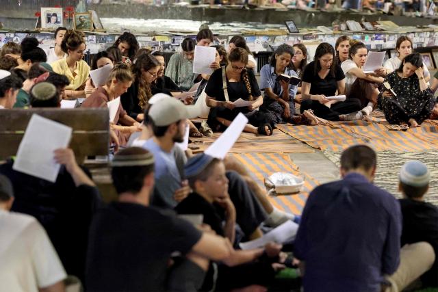 Religious and secular Israelis gather to read excerpts from the biblical Book of Lamentations in Tel Aviv on July 22, 2026, during the annual vigil of Tisha B'Av (the ninth day of Av) commemorating the destruction of the first and second temples in Jerusalem by the ancient Babylonians and Romans respectively. (Photo by JACK GUEZ / AFP)