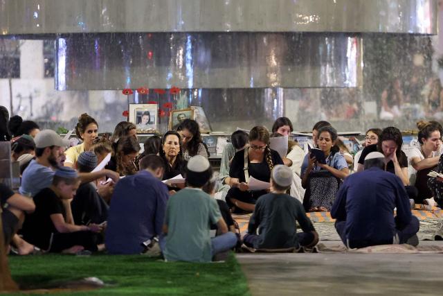 Religious and secular Israelis gather to read excerpts from the biblical Book of Lamentations in Tel Aviv on July 22, 2026, during the annual vigil of Tisha B'Av (the ninth day of Av) commemorating the destruction of the first and second temples in Jerusalem by the ancient Babylonians and Romans respectively. (Photo by JACK GUEZ / AFP)