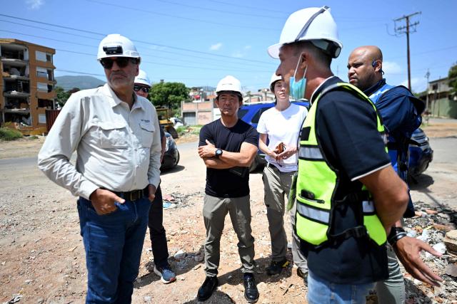 Japanese-US structural engineer Dr. Hideki "Kit" Miyamoto (C) observes buildings destroyed by the June 24 earthquakes in Catia La Mar, Venezuela, on July 20, 2026. (Photo by Juan BARRETO / AFP)