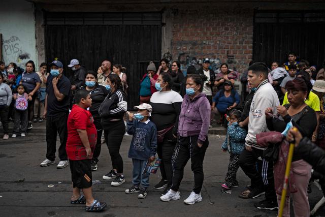 People remain outside a house where a fire killed ten people in Lima on July 22, 2026. A fire in a low-income neighborhood in Lima killed 10 people and destroyed two homes, Peru's civil defense reported. Two more people were injured, the INDECI civil defense institute wrote in a social media post. (Photo by ERNESTO BENAVIDES / AFP)