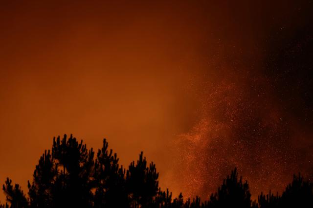 This photograph shows a wooden area engulfed in flames during a wildfire in Le Porge, south-western France on July 22, 2026. A fast-moving wildfire has burned 900 hectares north of Arcachon Bay in southwestern France, forcing the evacuation of more than 4,000 residents and tourists. The blaze, described by firefighters as exceptionally intense, spread sixfold in less than three hours through dense pine forests and is now advancing toward Ares and Lege-Cap-Ferret. The area was previously devastated by major wildfires in 2022. (Photo by ROMAIN PERROCHEAU / AFP)
