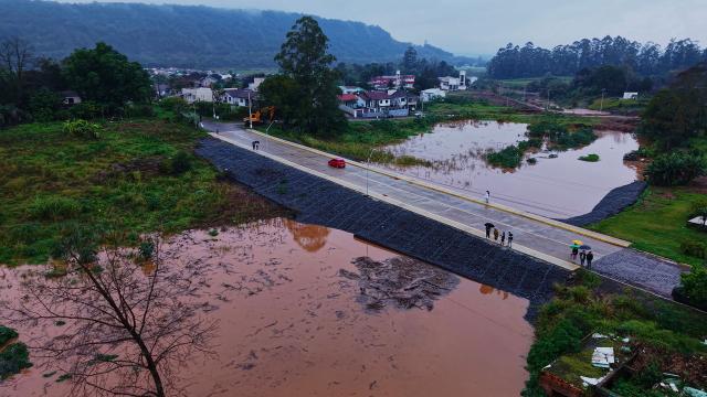 This aerial view shows the Aurelio Helio Moesch access road to the Porto XV neighborhood, built with a water drainage system designed to ensure access to the community during flooding of the Taquari River in Encantado, Rio Grande do Sul state, Brazil, on July 22, 2026. (Photo by Gustavo Ghisleni / AFP)