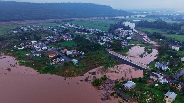This aerial view shows the Aurelio Helio Moesch access road to the Porto XV neighborhood, built with a water drainage system designed to ensure access to the community during flooding of the Taquari River in Encantado, Rio Grande do Sul state, Brazil, on July 22, 2026. (Photo by Gustavo Ghisleni / AFP)