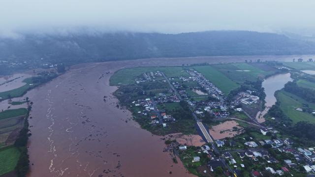 This aerial view shows the Aurelio Helio Moesch access road to the Porto XV neighborhood, built with a water drainage system designed to ensure access to the community during flooding of the Taquari River in Encantado, Rio Grande do Sul state, Brazil, on July 22, 2026. (Photo by Gustavo Ghisleni / AFP)