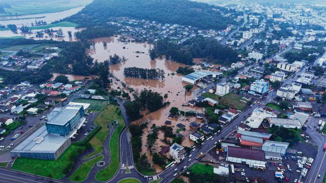 This aerial view shows the Caminhodromo and surrounding residential areas flooded by the overflowing Taquari River in Encantado, Rio Grande do Sul state, Brazil, on July 22, 2026. (Photo by Gustavo Ghisleni / AFP)