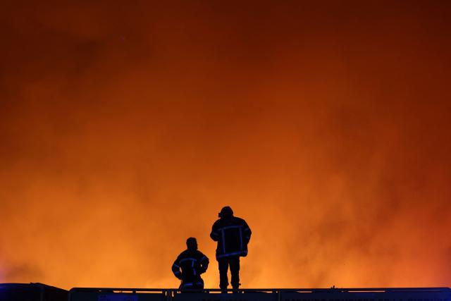 Firefighters monitor a wildfire in Le Porge, south-western France on July 22, 2026. A fast-moving wildfire has burned 900 hectares north of Arcachon Bay in southwestern France, forcing the evacuation of more than 4,000 residents and tourists. The blaze, described by firefighters as exceptionally intense, spread sixfold in less than three hours through dense pine forests and is now advancing toward Ares and Lege-Cap-Ferret. The area was previously devastated by major wildfires in 2022. (Photo by ROMAIN PERROCHEAU / AFP)