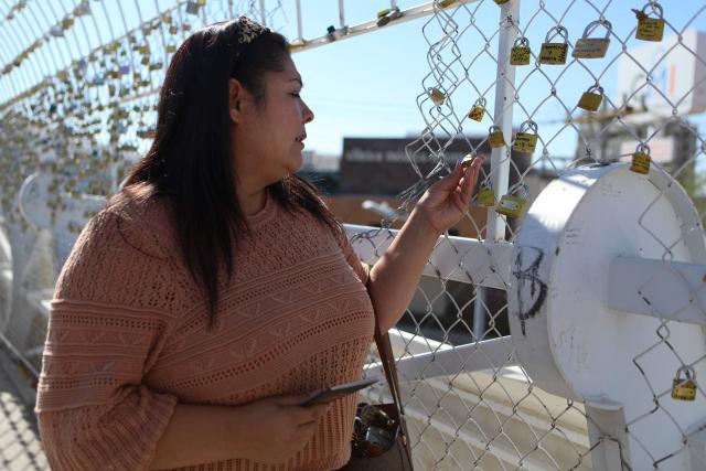A woman looks at the messages of thanks engraved on locks commemorating the successful completion of U.S. immigration processes at the "Bridge of Hope" or "Bridge of Wishes" in Ciudad Juarez, Mexico, on July 22, 2026. (Photo by Herika Martinez / AFP)