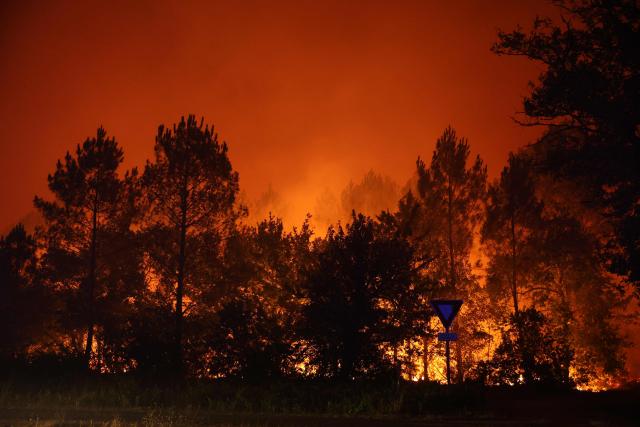 A wildfire rages through a forestry area in Le Porge, south-western France early on July 23, 2026. A fast-moving wildfire has burned 900 hectares north of Arcachon Bay in southwestern France, forcing the evacuation of more than 4,000 residents and tourists. The blaze, described by firefighters as exceptionally intense, spread sixfold in less than three hours through dense pine forests and is now advancing toward Ares and Lege-Cap-Ferret. The area was previously devastated by major wildfires in 2022. (Photo by ROMAIN PERROCHEAU / AFP)