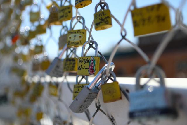 Messages of thanks engraved on locks commemorate the successful completion of U.S. immigration processes are pictured at the "Bridge of Hope" or "Bridge of Wishes" in Ciudad Juarez, Mexico, on July 22, 2026. (Photo by Herika Martinez / AFP)