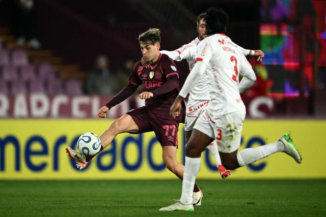 Lanus' forward #77 Lucas Besozzi and Cienciano's Argentine midfielder #16 Marcos Martinich (back) fight for the ball during the first leg of the Copa Sudamericana knockout round play-off football match between Argentina's Lanus and Peru's Cienciano, at the Ciudad de Lanus stadium, in Lanus, Buenos Aires province, Argentina on July 22, 2026. (Photo by Luis ROBAYO / AFP)