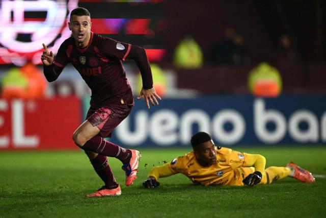 Lanus' midfielder #23 Ramiro Carrera celebrates past Cienciano's goalkeeper #31 Italo Espinoza after scoring his team's second goal during the first leg of the Copa Sudamericana knockout round play-off football match between Argentina's Lanus and Peru's Cienciano, at the Ciudad de Lanus stadium, in Lanus, Buenos Aires province, Argentina on July 22, 2026. (Photo by Luis ROBAYO / AFP)