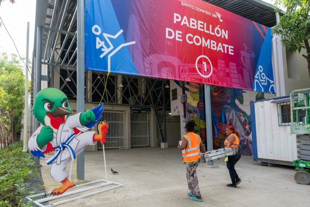 Workers carry a ladder during preparations for the XXV Central American and Caribbean Games in Santo Domingo on July 22, 2026. The XXV Central American and Caribbean Games - Santo Domingo 2026, will be held from July 24 to August 8, 2026, in the Dominican Republic. (Photo by Francesco SPOTORNO / AFP)