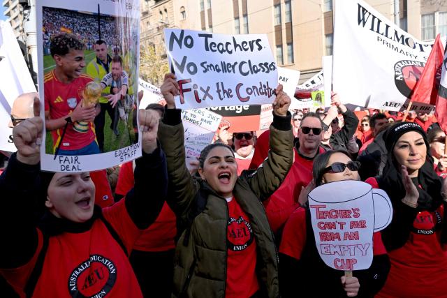 Teachers march through Melbourne's city centre to protest over pay and conditions on July 23, 2026. Tens of thousands of public school teachers went on strike following a pay dispute with the state government, closing or disrupting some 500 state schools. (Photo by William WEST / AFP)