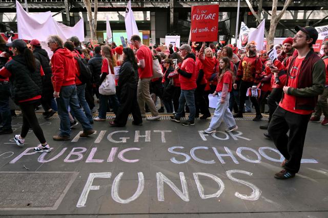 Teachers march through Melbourne's city centre to protest over pay and conditions on July 23, 2026. Tens of thousands of public school teachers went on strike following a pay dispute with the state government, closing or disrupting some 500 state schools. (Photo by William WEST / AFP)
