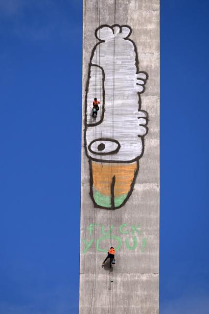 EDITORS NOTE: Graphic content / Abseilers prepare to paint over Pam the Bird graffiti on Melbourne's Bolte Bridge on July 23, 2026. The graffiti was spray-painted on one of the bridge's 140-metre-tall pylons by alleged vandal Jack Gibson-Burrell and it is expected to take several days, taking 100 litres of surface preparation, primer and paint. (Photo by William WEST / AFP)