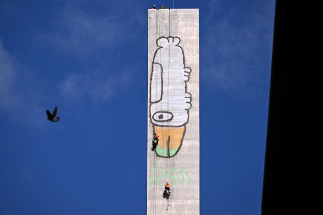 EDITORS NOTE: Graphic content / Abseilers prepare to paint over Pam the Bird graffiti on Melbourne's Bolte Bridge on July 23, 2026. The graffiti was spray-painted on one of the bridge's 140-metre-tall pylons by alleged vandal Jack Gibson-Burrell and it is expected to take several days, taking 100 litres of surface preparation, primer and paint. (Photo by William WEST / AFP)