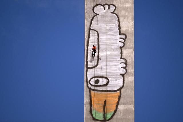 Abseilers prepare to paint over Pam the Bird graffiti on Melbourne's Bolte Bridge on July 23, 2026. The graffiti was spray-painted on one of the bridge's 140-metre-tall pylons by alleged vandal Jack Gibson-Burrell and it is expected to take several days, taking 100 litres of surface preparation, primer and paint. (Photo by William WEST / AFP)