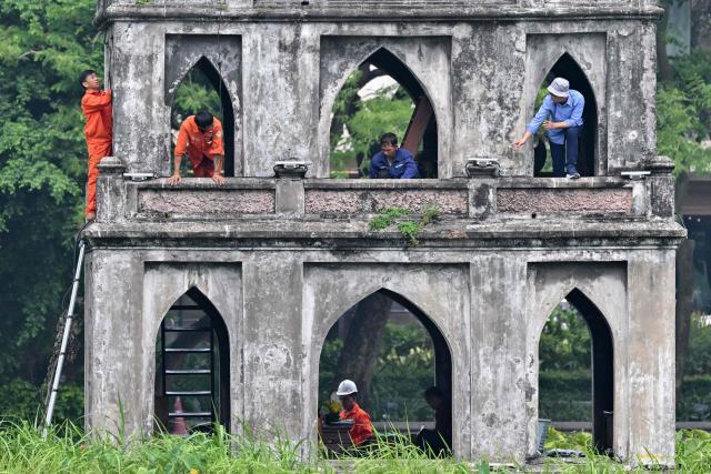 Workers renovate the "Thap Rua" (Turtle Tower) at Hoan Kiem Lake in Hanoi on July 23, 2026. (Photo by Nhac NGUYEN / AFP)