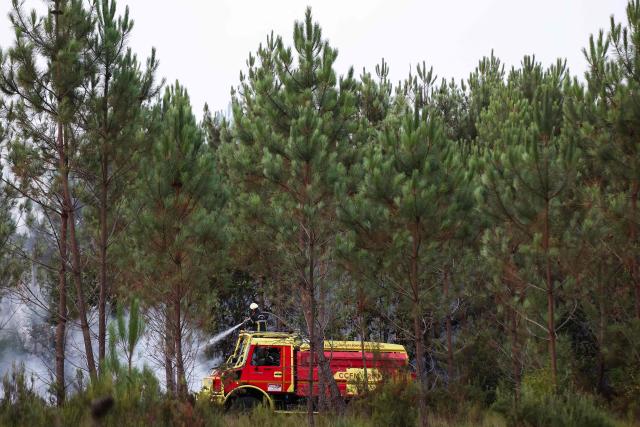 Firefighters extinguishing fires from a wildland water truck in Le Porge, southwestern France on July 23, 2026, following a wildfire and the evacuation of the residents. A highly virulent wildfire has swept through more than 2,000 hectares since July 22, 2026 near the Arcachon Basin (Gironde), where nearly 12,000 residents and tourists have been evacuated in total from this area of the Landes de Gascogne forest, already devastated by flames in 2022. (Photo by ROMAIN PERROCHEAU / AFP)