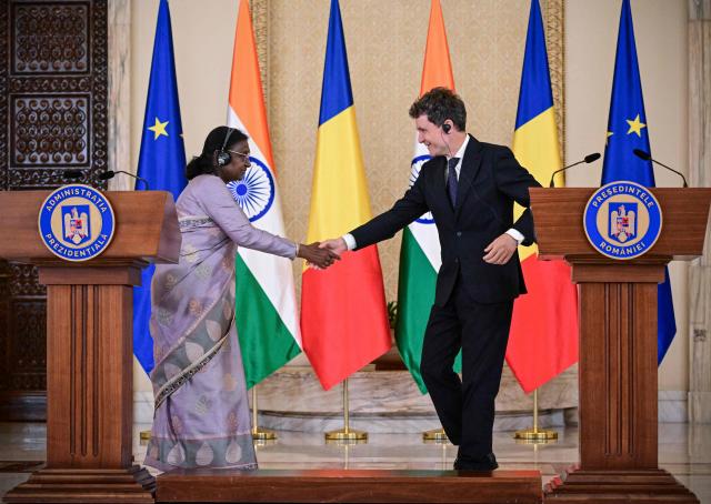 Indian President Droupadi Murmu (L) shakes hands with Romanian President Nicusor Dan at the end of a joint press conference at the presidential Cotroceni Palace in Bucharest on July 23, 2026. Indian President Droupadi Murmu is on a three-day state visit to Romania. (Photo by Daniel MIHAILESCU / AFP)