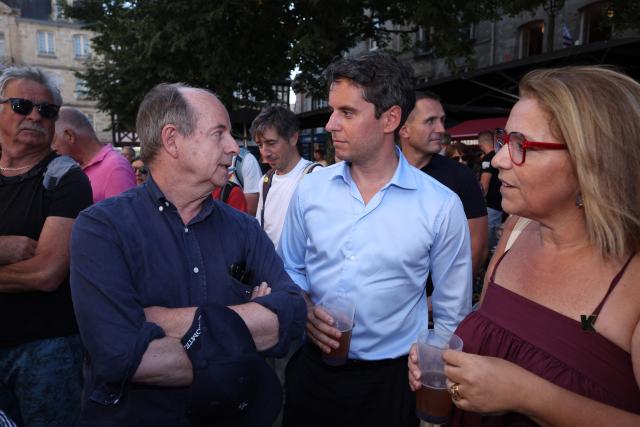 General Secretary of French centrist party Renaissance and upcoming presidential election candidate Gabriel Attal (C), accompanied by French MP Annaïg Le Meur (R), meet former French Justice Minister Jean-Jacques Urvoas (2ndL) as they visit the Cornouailles festival in Quimper, western France, on July 23, 2026. (Photo by FRED TANNEAU / AFP)
