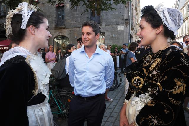 General Secretary of French centrist party Renaissance and upcoming presidential election candidate Gabriel Attal (C) meets with participants dressed in traditional Breton costume as he visits the Cornouailles festival in Quimper, western France, on July 23, 2026. (Photo by FRED TANNEAU / AFP)