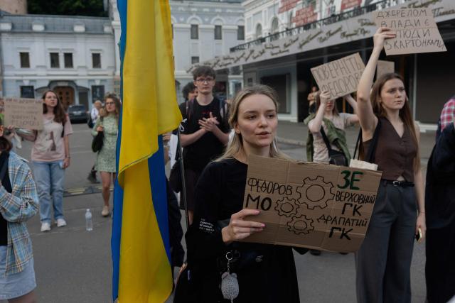 Protesters hold placards during on the eighth day of a demonstration against Ukraine's President's decision to dismiss Ukraine's former Defence Minister, in Kyiv on July 23, 2026, amid the Russian invasion of Ukraine. Ukraine's ex-defence minister -- whose ousting trigged a week of protests and forced out the country's commander-in-chief -- said on July 23, 2026, he was rejecting offers by Ukraine's President for a new role. (Photo by Tetiana DZHAFAROVA / AFP)