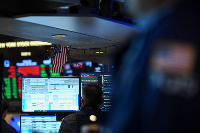 A trader works on the floor of the New York Stock Exchange (NYSE) in New York on July 23, 2026. Wall Street stocks tumbled on Thursday as oil prices shot higher on worsening effects of the US-Iran war while Tesla and Google parent Alphabet fell sharply after earnings reports.  International oil benchmark Brent North Sea crude topped $100 a barrel after Yemen's Iran-backed Houthi rebels struck oil tankers in the Red Sea. The attack brought the war roiling the Middle East to a new front. (Photo by ANGELA WEISS / AFP)
