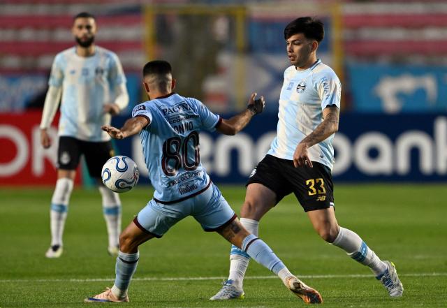 Bolivar's midfielder #80 Carlos Antonio Melgar (L) and Gremio's Argentine midfielder #33 Leonel Perez fight for the ball during the first leg of the Copa Sudamericana knockout round play-off football match between Bolivia's Bolivar and Brazil's Gremio at the Hernando Siles stadium in La Paz, on July 23, 2026. (Photo by AIZAR RALDES / AFP)