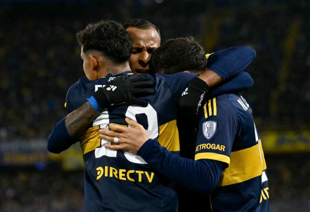 Boca Juniors' Uruguayan forward #16 Miguel Merentiel (R) celebrates with his teammates Boca Juniors' forward #19 Leonel Flores and Boca Juniors' Colombian forward #22 Sebastian Villa after scoring his team's first goal during the first leg of the Copa Sudamericana knockout round play-off football match between Argentina's Boca Juniors and Chile's O'Higgins at La Bombonera stadium, in Buenos Aires, on July 23, 2026. (Photo by Luis ROBAYO / AFP)