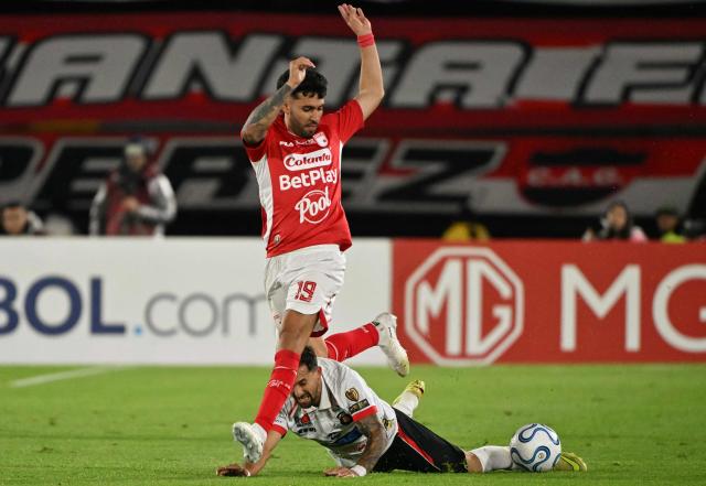 Santa Fe's Argentine forward #19 Nahuel Bustos and Caracas' forward #07 Robert Hernandez fight for the ball during the first leg of the Copa Sudamericana knockout round play-off football match between Colombia's Independiente Santa Fe and Venezuela's Caracas, at the Nemesio Camacho 'El Campin' stadium in Bogota, on July 23, 2026. (Photo by Luis ACOSTA / AFP)