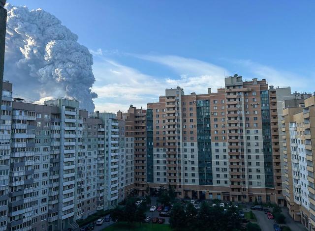 This picture taken on July 24, 2026 in Saint Petersburg shows smoke (L) rising into the sky over residential buildings. Ukrainian drones hit a warehouse for a Russian e-commerce giant near Saint Petersburg early on July 24, triggering a fire that sent smoke pouring over the historic city, according to local officials and an AFP reporter. (Photo by AFP)