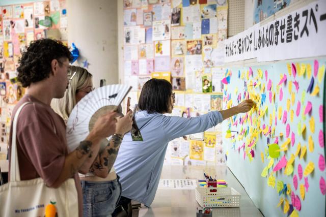Visitors place birthday messages on a wall for the almost one-year-old male Japanese macaque monkey from named 'Punch', who was abandoned by his mother shortly after birth, at Ichikawa City Zoo and Botanical Gardens in Ichikawa on July 24, 2026. (Photo by Philip FONG / AFP)