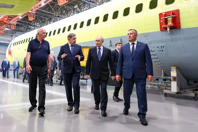 In this pool photograph distributed by the Russian state agency Sputnik, Russia's President Vladimir Putin (2nd-R), accompanied by Rostec CEO Sergei Chemezov (L), Irkutsk Aviation Plant Director Andrey Soynov (2nd-L) and Irkutsk Region Governor Igor Kobzev (R), visits the Irkutsk Aviation Plant in Irkutsk on July 24, 2026. (Photo by Vyacheslav PROKOFYEV / POOL / AFP)