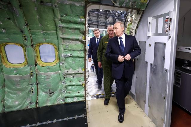 In this pool photograph distributed by the Russian state agency Sputnik, Russia's President Vladimir Putin (R) listens to explanations as he visits the Irkutsk Aviation Plant in Irkutsk on July 24, 2026. (Photo by Vyacheslav PROKOFYEV / POOL / AFP)